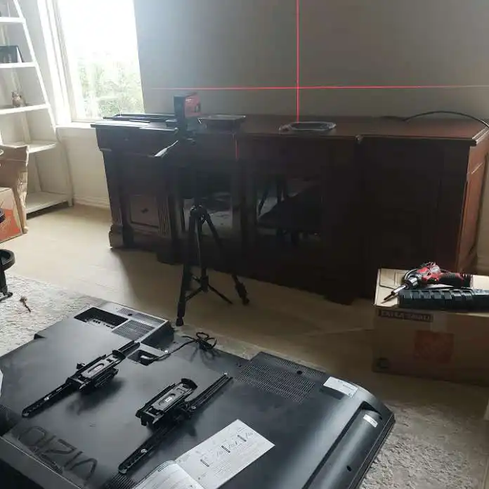 A living room setup featuring a TV, a tripod, and a wooden cabinet.