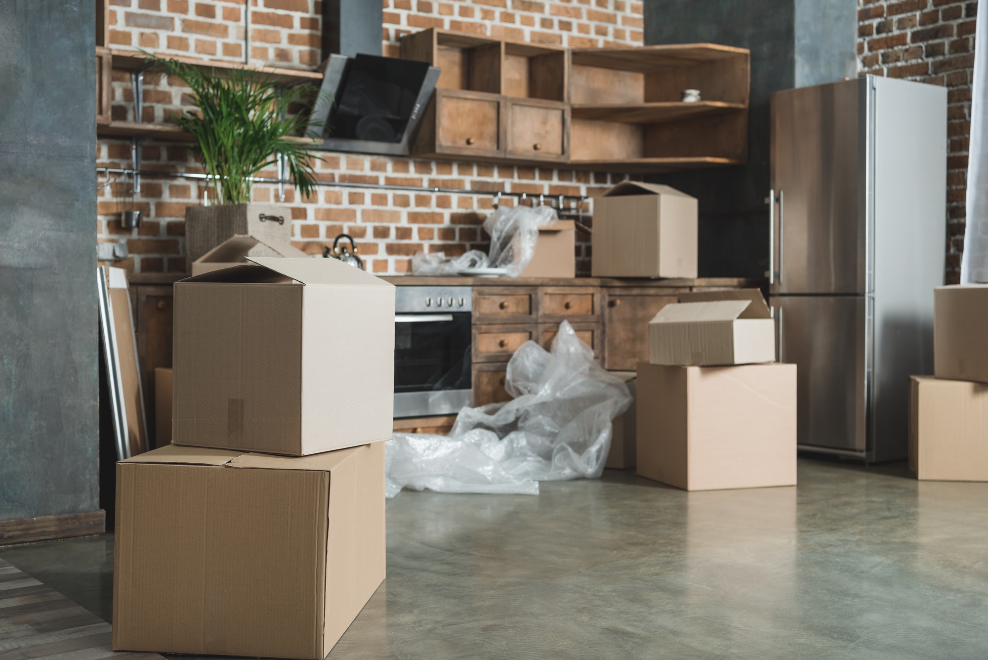 Inicio cardboard boxes in empty kitchen during relocation